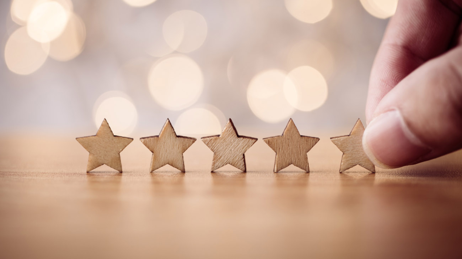 Hand putting wooden five star shape on table. The best excellent business services rating customer experience concept.