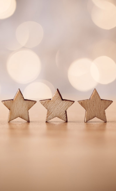 Hand putting wooden five star shape on table. The best excellent business services rating customer experience concept.